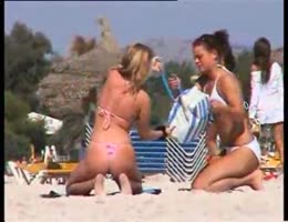 un voyeur filme des filles qui se passent de la crème à la plage en mode voyeur
